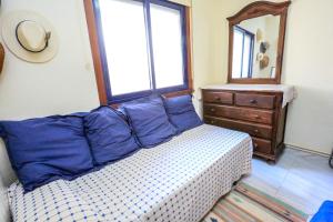 坎布里尔斯Roger ONLY FAMILIES的一间卧室配有一张带蓝色枕头和镜子的床