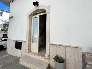 佩斯基奇Minimà Peschici的白色建筑上一扇门,有窗户