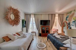 塔拉斯孔Hotel Des Artistes的酒店客房设有两张床和电视。