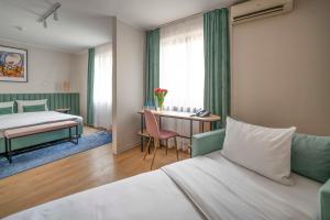 克拉科夫Hotel H12****的酒店客房配有一张床铺和一张桌子。