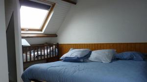 LanvéocGite des confitures à Lanvéoc-Crozon的卧室配有带枕头的床铺和窗户。