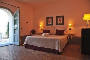 Lingua博尔戈迪马尔拉萨利纳酒店的一间卧室配有一张带橙色墙壁的大床