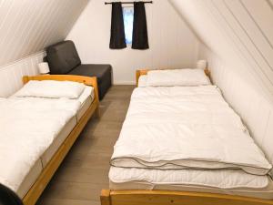 格洛韦Haus Lisa的小型客房配有两张床铺和椅子