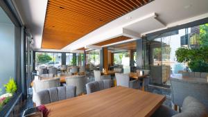 安塔利亚卡夫卡斯酒店的餐厅设有木桌、椅子和窗户。