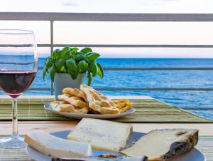 菲纳莱利古雷La Vela的一张桌子,上面放着一盘奶酪和一杯葡萄酒