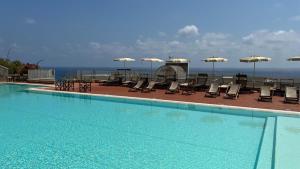 菲纳莱利古雷La Vela的一个带椅子和遮阳伞的大型游泳池