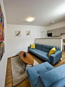 利贝雷茨Gallery Apartments的客厅配有蓝色的沙发和桌子