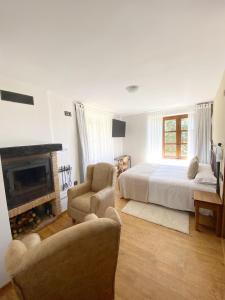 皮尔托贝加Hotel Rural Candela y Plata的一间白色卧室,配有一张床和一个壁炉