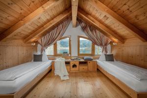 博登斯多夫Seehotel Urban的客房设有两张床铺、木制天花板和窗户。