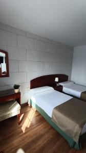 巴尔韦尔德回力镖酒店的一间卧室设有两张床和一堵墙