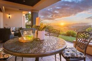 克尼斯纳Pezula Magic Retreat - 4 Bedroom Home with Inverter的露台上的一张桌子,享有日落美景