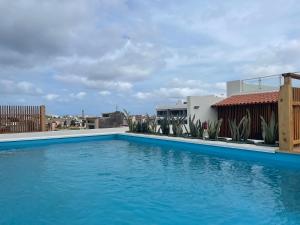 萨尔雷Oasis White Hotel的一座大型蓝色游泳池,位于一座建筑的顶部