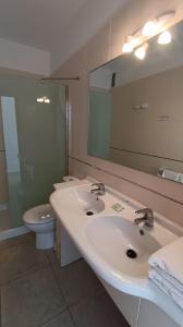 塔马达斯特布姆兰一号公寓的浴室设有2个水槽、卫生间和镜子。