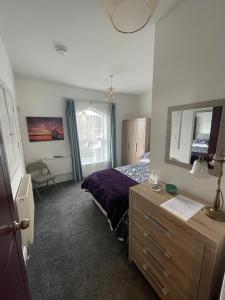 SandycroftVictoria Villas的一间卧室配有一张床、梳妆台和镜子