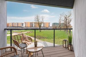 格但斯克RentPlanet - Apartamenty Chlebova的阳台配有桌椅和大窗户。
