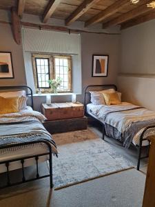 WestonWilde Rooms的一间卧室设有两张床和窗户。