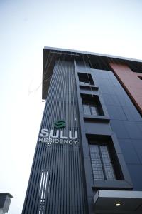 埃尔讷古勒姆Sulu Residency的一座高大的建筑,上面有苏迪曼的能源标志