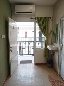 班达楠榜RUMAH KOPI SYARIAH HOTEL的浴室设有通往阳台的门