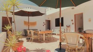 伊斯费古耶拉尔海滩Hostal Esfigueral的庭院配有桌椅和遮阳伞。