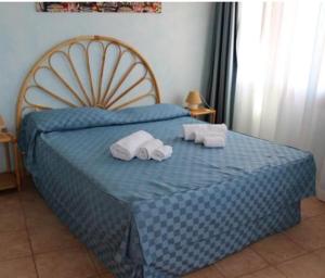 维拉普特祖Residence Il Borgo di Porto Corallo的一间卧室配有蓝色的床和毛巾