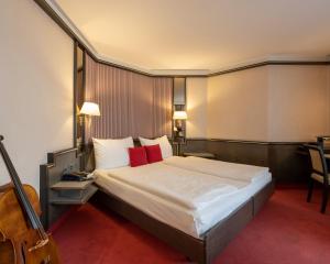 卢塞恩诺普尔卢塞恩酒店的酒店客房配有一张带红色枕头的大床
