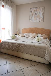 菲乌米奇诺吉拉莫多卢克谢费莱珀特公寓的一间卧室配有一张带鲜花的大床