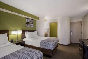 梅萨SureStay Plus by Best Western Mesa Superstition Springs的一间酒店客房,设有两张床和绿色的墙壁
