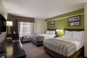 梅萨SureStay Plus by Best Western Mesa Superstition Springs的酒店客房设有两张床和电视。