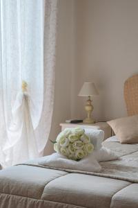 菲乌米奇诺吉拉莫多卢克谢费莱珀特公寓的两张床,配有白色窗帘和一束玫瑰花