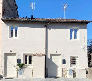 卡潘诺里Relax&Business [Wi-fi, TV HD, Parcheggio gratuito]的一座白色的大建筑,设有两扇车库门