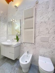 卡潘诺里Relax&Business [Wi-fi, TV HD, Parcheggio gratuito]的白色的浴室设有水槽和卫生间。