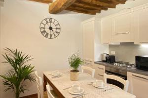卡潘诺里Relax&Business [Wi-fi, TV HD, Parcheggio gratuito]的厨房配有桌子和墙上的时钟