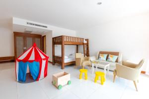纳仲天Pinnacle Grand Jomtien Resort and Beach Club - SHA Extra Plus的一间设有帐篷、一张床和椅子的房间
