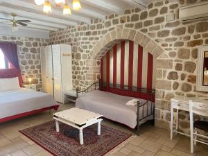 纳夫普利翁迈拉尔宾馆的一间卧室设有两张床和石墙