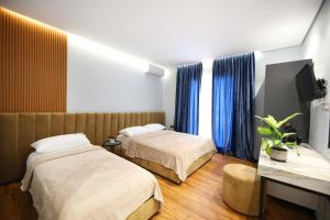 伏罗拉Ulcas guest huse的酒店客房设有两张床和电视。