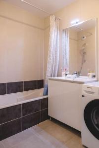 布雷斯地区布尔格Superbe appartement 2 chambres - parking gratuit的带浴缸、水槽和洗衣机的浴室