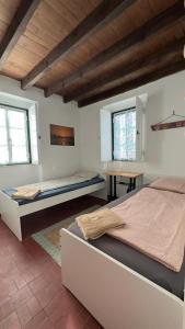 卡帕里卡海岸GetWet SurfCamp II的一间卧室设有两张床、一张桌子和两个窗户。