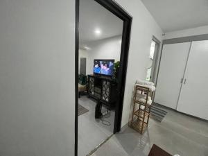 莫龙One Bedroom Condo Subic Bay的镜子反射着客厅,客厅配有电视