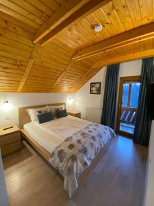 巴亚斯普列Pintea Chalet的一间卧室设有一张带木制天花板的大床