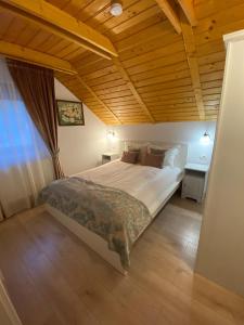 巴亚斯普列Pintea Chalet的一间卧室设有一张带木制天花板的大床