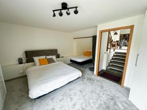 吉维尼W27B - Alla Prima, Super villa au cœur de Giverny的一间卧室配有床、镜子和楼梯