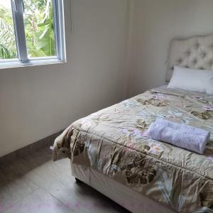北干巴鲁Rumah Tropis - Lantai 1的一间卧室配有一张带毯子的床和窗户