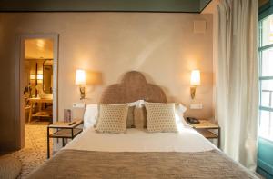 塞维利亚Hospes Las Casas Del Rey De Baeza, Seville, a Member of Design Hotels的卧室配有带枕头的大型白色床