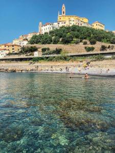 切尔沃Casa del 1400 nell'antico Borgo di Cervo的和水中的人一起欣赏海滩的景色