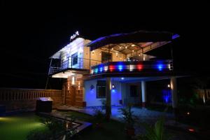 布巴内什瓦尔Goroomgo Bottom Up Villa Swimming Pool Bhubaneswar的享有蓝色灯光的房子的夜景
