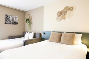 布鲁日布鲁日格林公园酒店的配有白色床单的酒店客房内的两张床