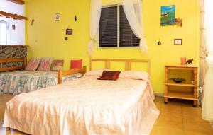 巴列埃尔莫索One bedroom house with enclosed garden and wifi at Vallehermoso 3 km away from the beach的一间卧室设有两张床和黄色的墙壁