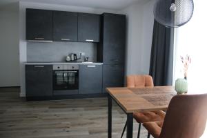 SteenbergenHotel Studio SIS的厨房配有黑色橱柜和木桌