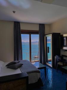 维耶特里拉卢瑟托拉酒店的一间卧室配有一张床,享有海景