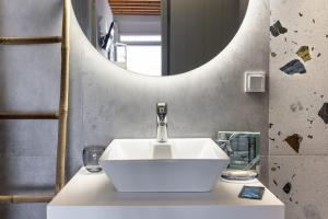 基莫洛斯岛Ωκεανίς Κίμωλος的浴室设有白色水槽和镜子